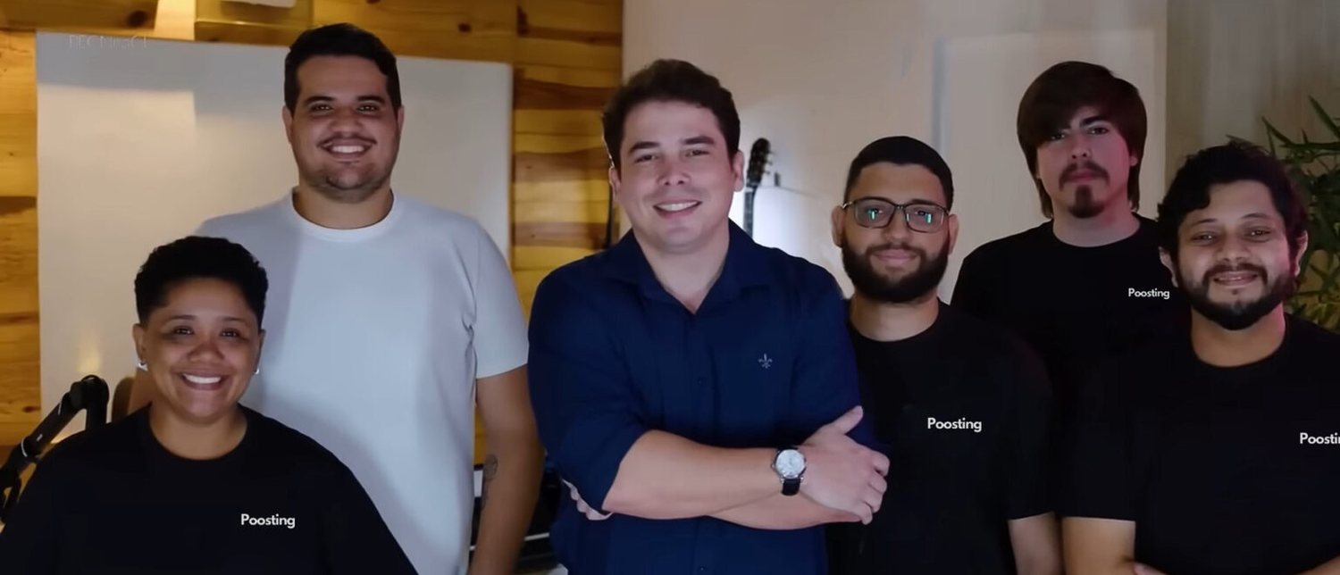 Equipe da Poosting reunida com camisetas da marca, ao lado do fundador Afonso Alcântara